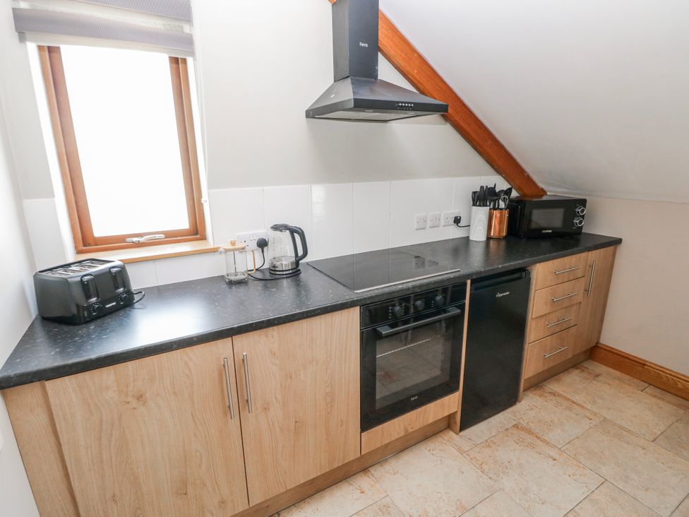 A kitchen with appliances and cabinetry at Ivy Cottage, Oldwalls, Llanrhidian, Gower