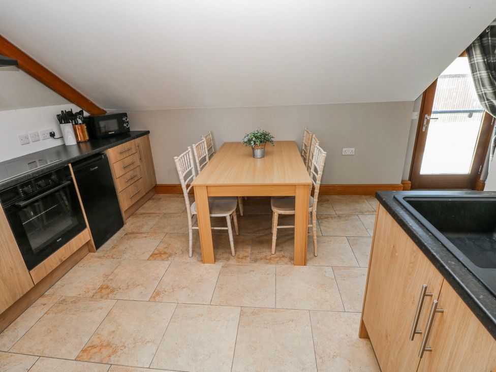 A kitchen with a dining table and chairs at Ivy Cottage in Oldwalls, Llanrhidian, Gower
