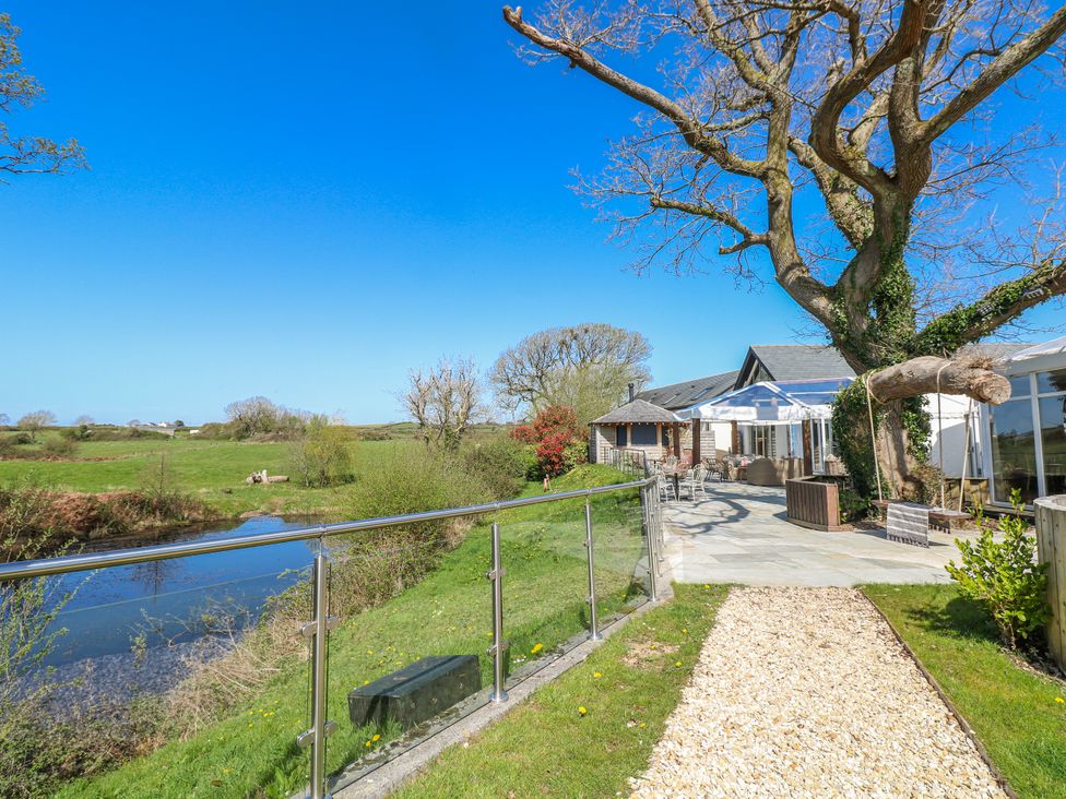 An outdoor area with a patio and river view at Ivy Cottage Oldwalls, Llanrhidian, Gower