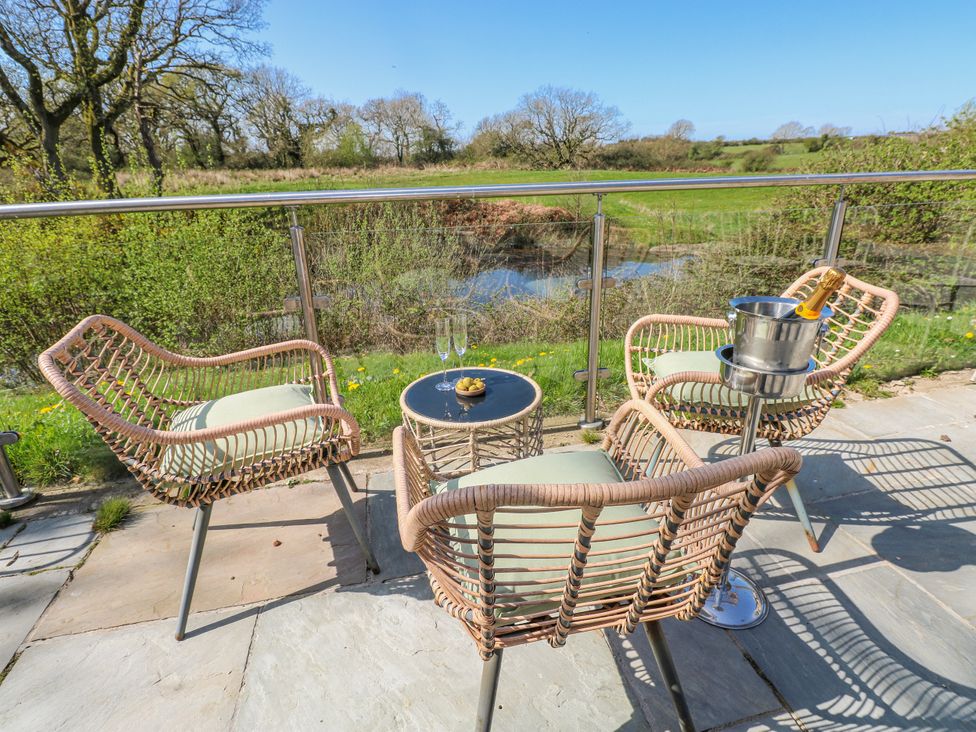 An outdoor seating area with chairs and a table at Ivy Cottage, Oldwalls, Llanrhidian, Gower