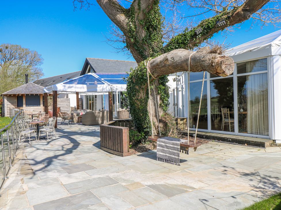 An outdoor area with a swing and seating at Ivy Cottage in Oldwalls, Llanrhidian, Gower