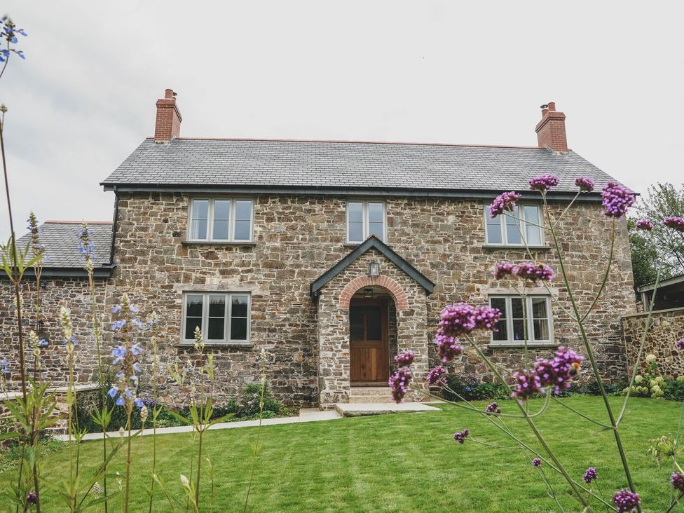 A house with stone walls and windows in the garden at Knowle House Okehampton