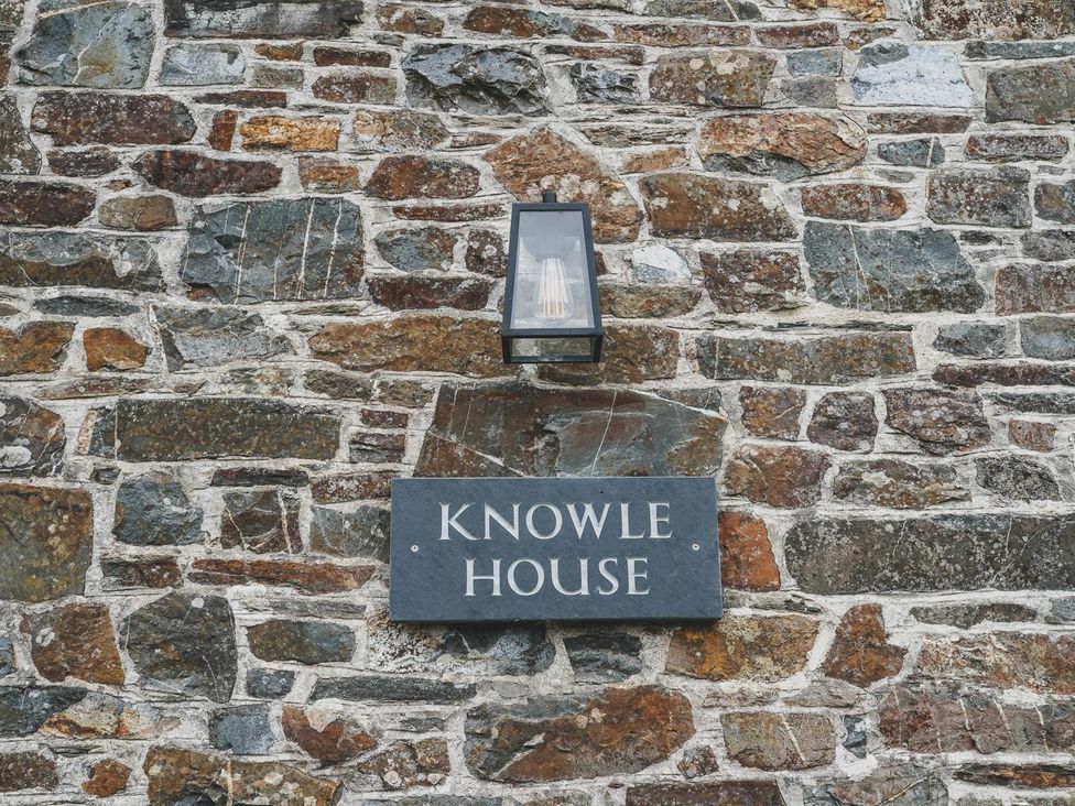 A wall with a nameplate and light fixture at Knowle House Okehampton