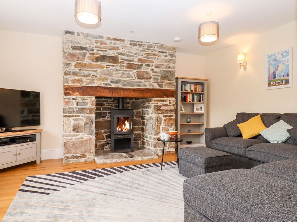 A living room with a fireplace and sofa at Knowle House in Okehampton
