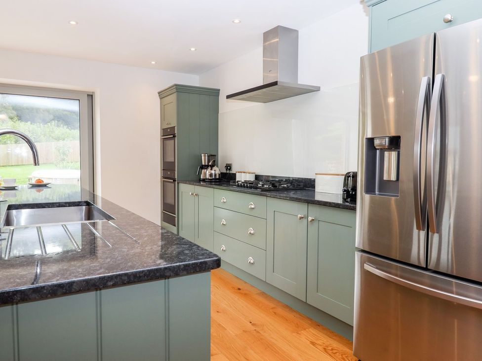 A kitchen with a sink and refrigerator at Knowle House Okehampton