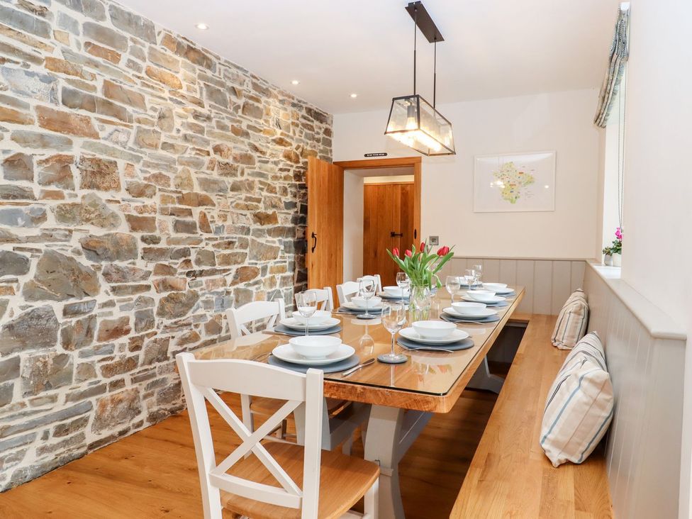 A dining room with a wooden table and chairs at Knowle House in Okehampton