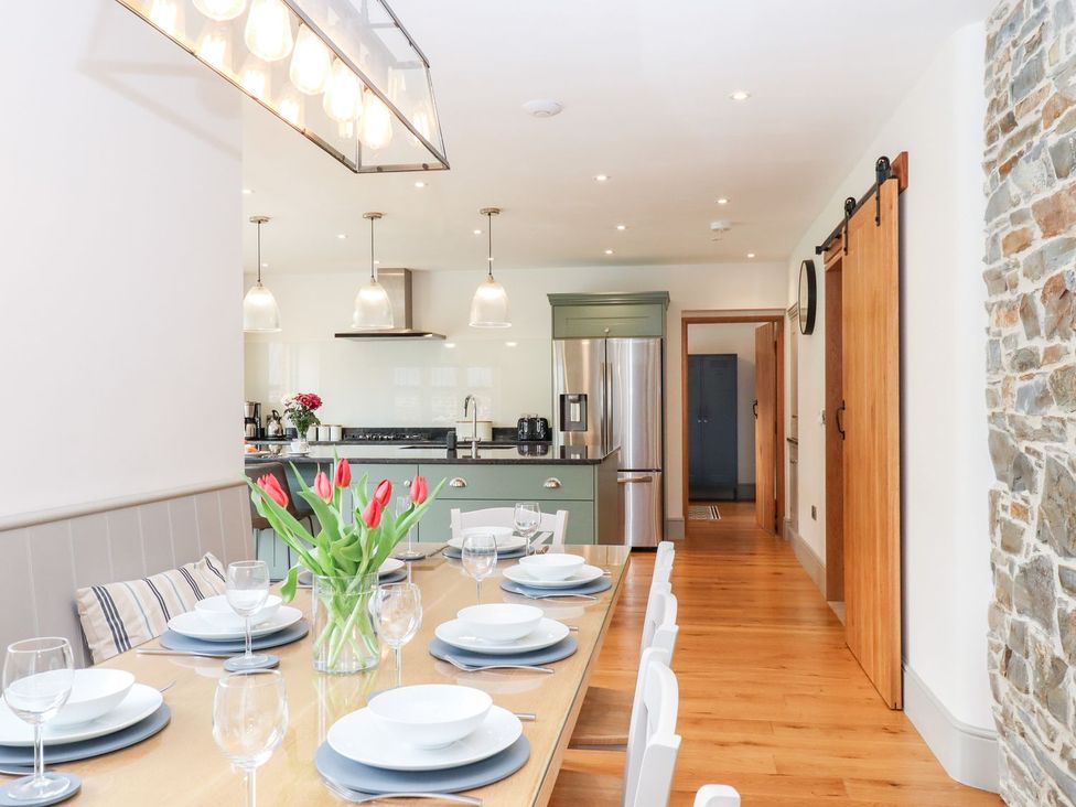A dining room with a table set for a meal at Knowle House in Okehampton