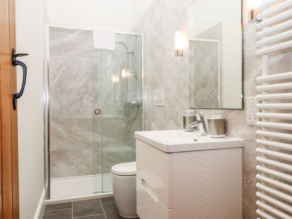A bathroom with a shower, toilet, and vanity at Knowle House Okehampton