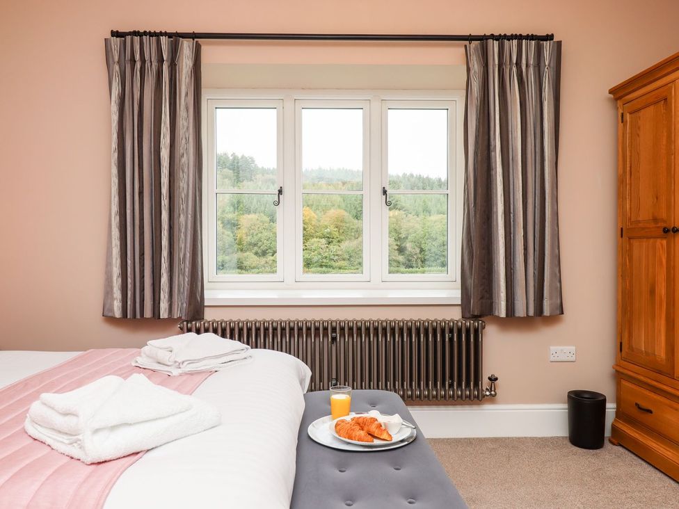 A bedroom with a window and breakfast on a plate at Knowle House Okehampton