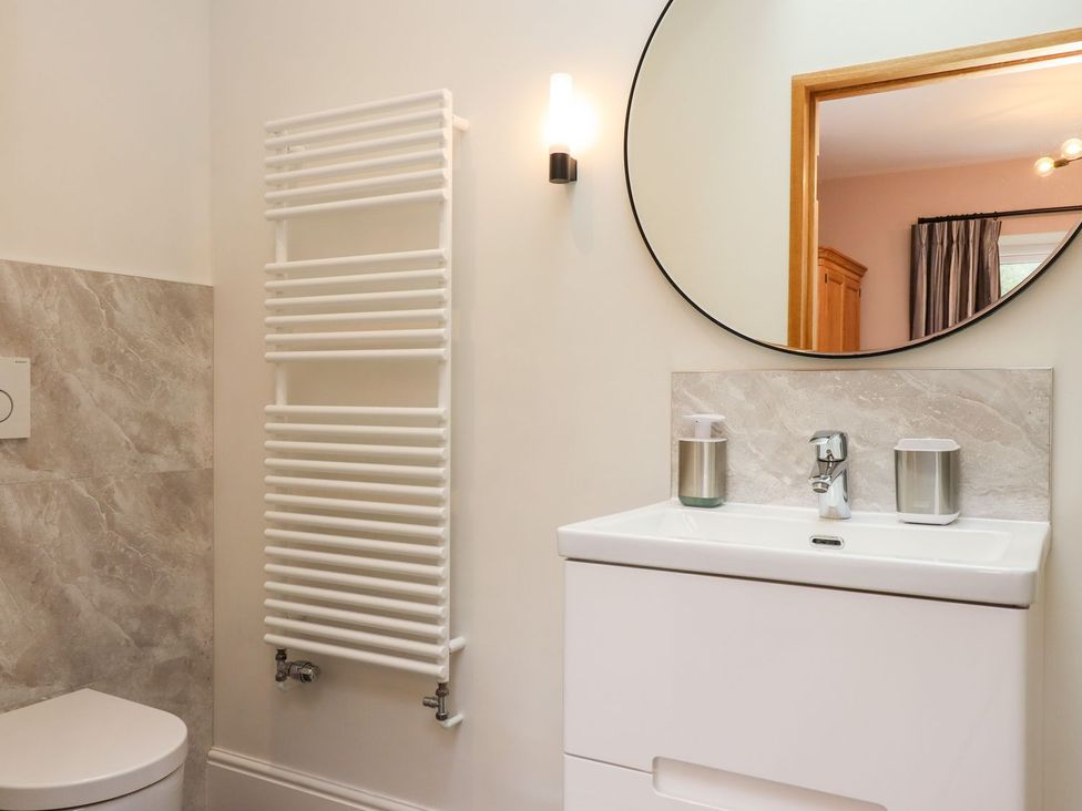 A bathroom with a sink and mirror at Knowle House in Okehampton