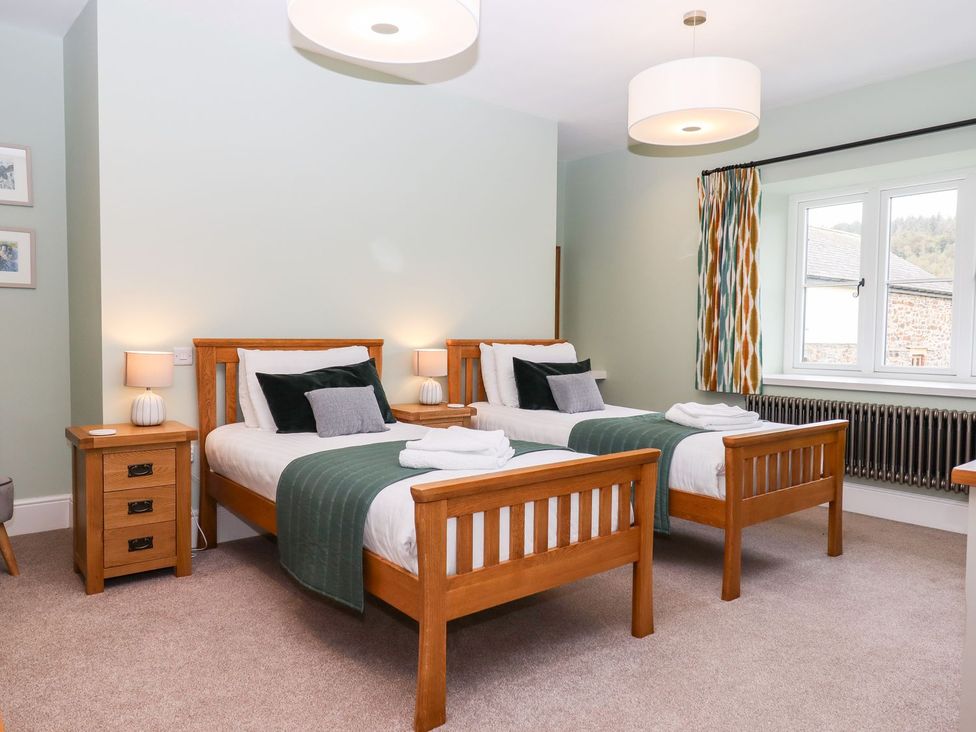 A bedroom with two single beds and a window at Knowle House in Okehampton