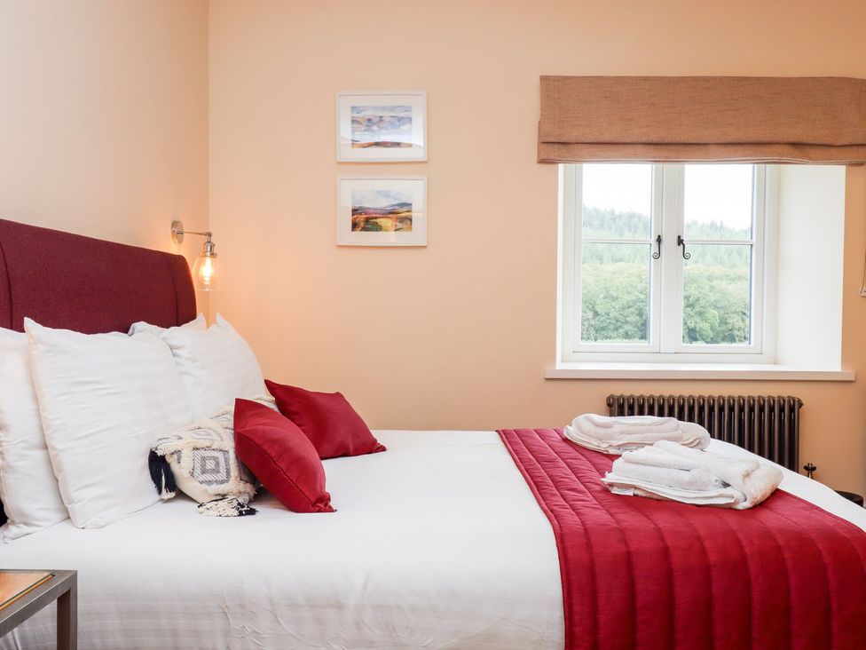 A bedroom with a bed and window at Knowle House in Okehampton