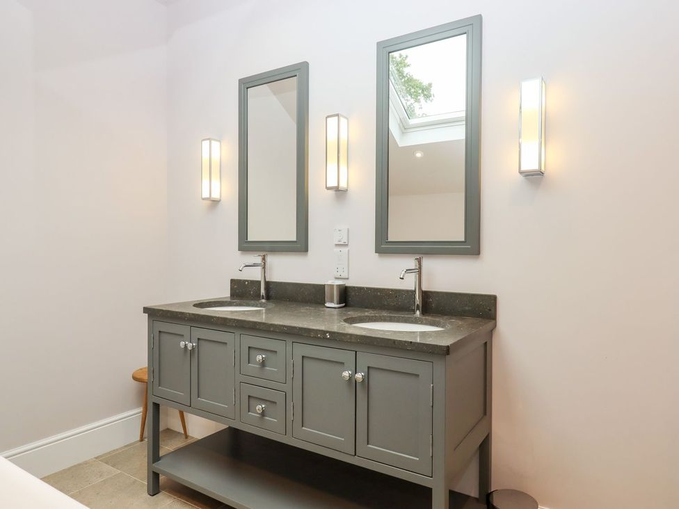 A bathroom with a double vanity and mirrors at Knowle House in Okehampton