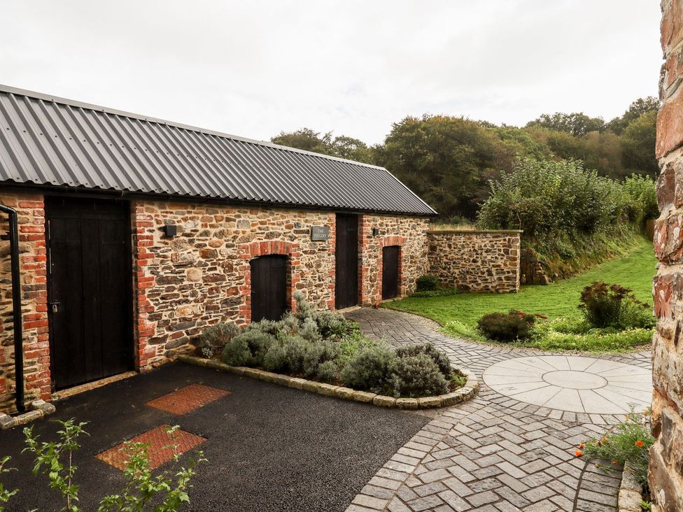 An outdoor area with a stone building and pathway at Knowle House in Okehampton