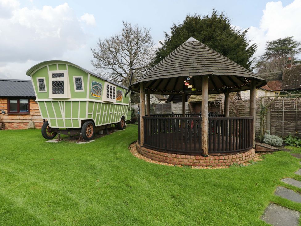 A garden with a caravan and gazebo at The Gypsy Caravan in Marlborough