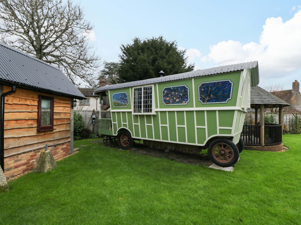 A green caravan in a garden at The Gypsy Caravan in Marlborough
