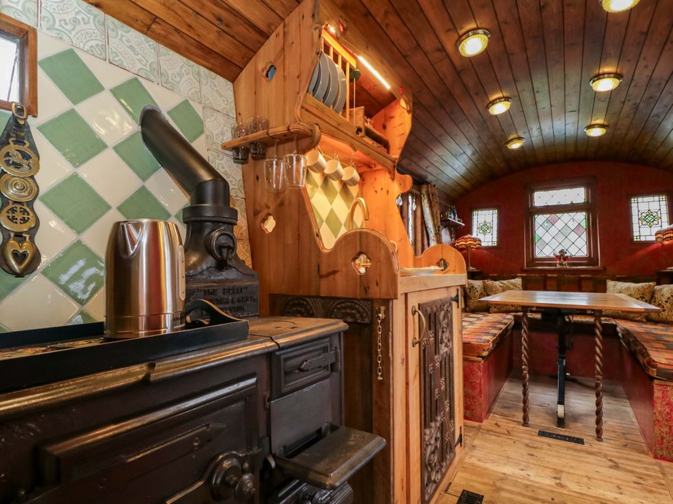 A kitchen with a stove and seating area at The Gypsy Caravan in Marlborough
