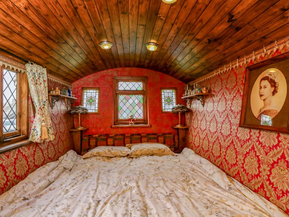 A bedroom with a bed and decorative items at The Gypsy Caravan in Marlborough