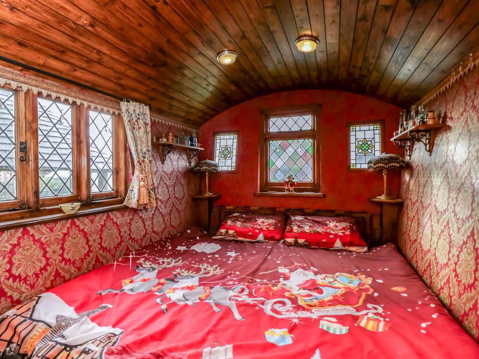 A bedroom with a bed and decorative windows at The Gypsy Caravan in Marlborough