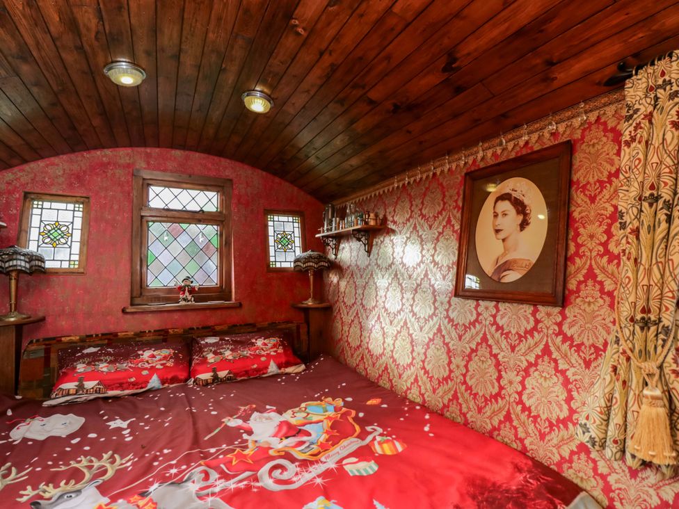 A bedroom with a bed and stained glass windows at The Gypsy Caravan in Marlborough