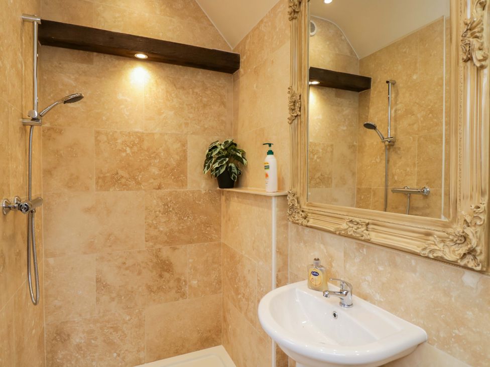A bathroom with a shower and sink at The Gypsy Caravan in Marlborough