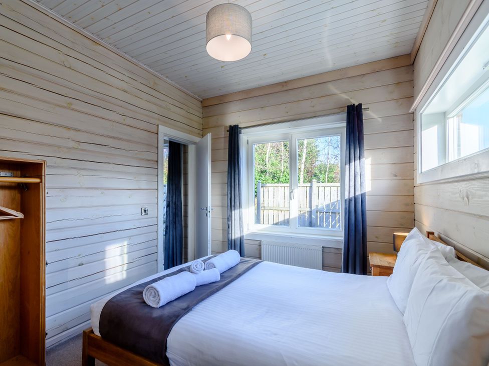 A bedroom with a bed and towels at Chestnut Spa (Pet) Carlton Miniott near Thirsk