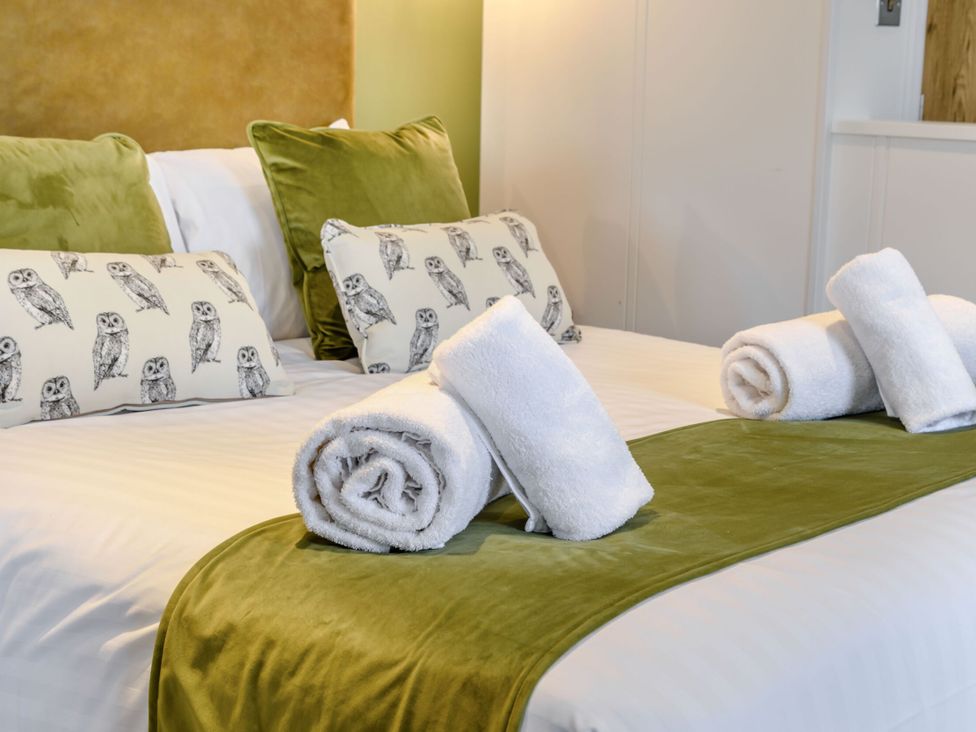 A bedroom with a bed and pillows at Pear Tree Spa (Pet) Carlton Miniott near Thirsk