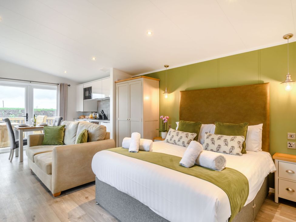 A bedroom with a bed and sofa at Pear Tree (Pet) Carlton Miniott near Thirsk