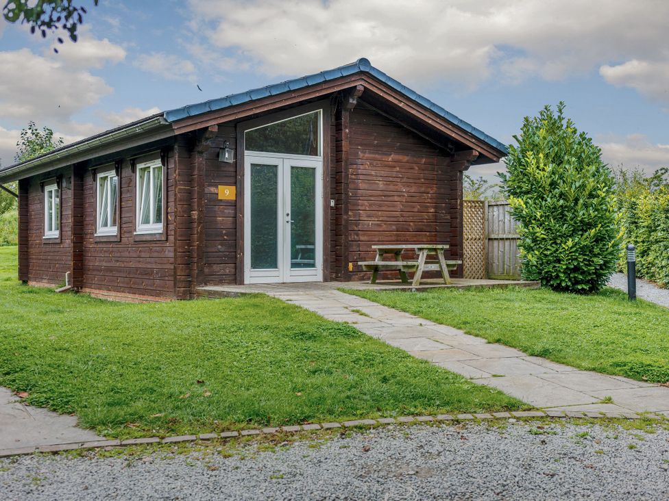 A cabin with a picnic table and pathway at Yew Tree Spa (Pet) Carlton Miniott near Thirsk
