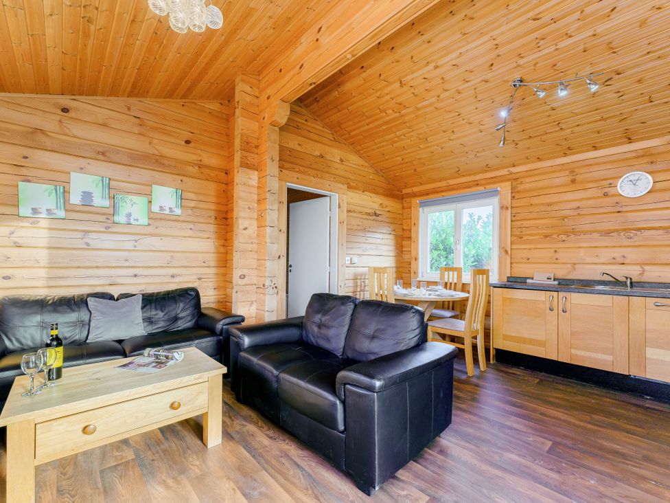 A living room with a sofa and dining area at Yew Tree Spa (Pet) in Carlton Miniott near Thirsk