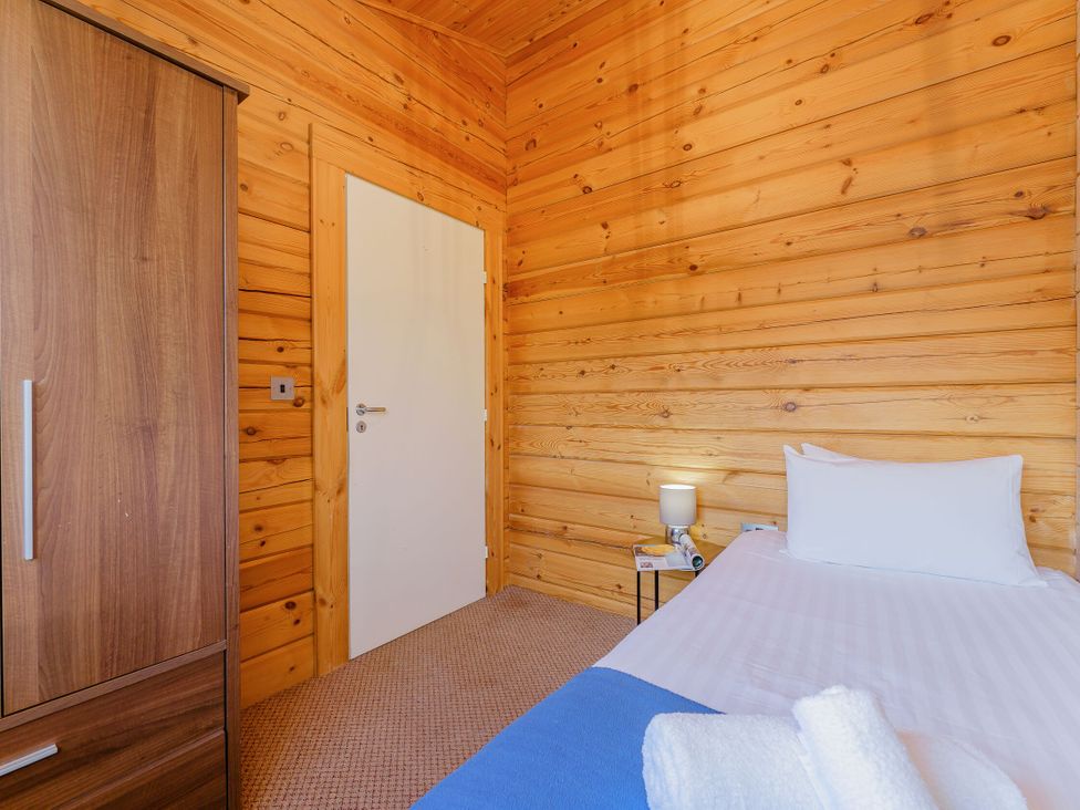 A bedroom with a bed and wardrobe at Yew Tree Spa (Pet) Carlton Miniott near Thirsk