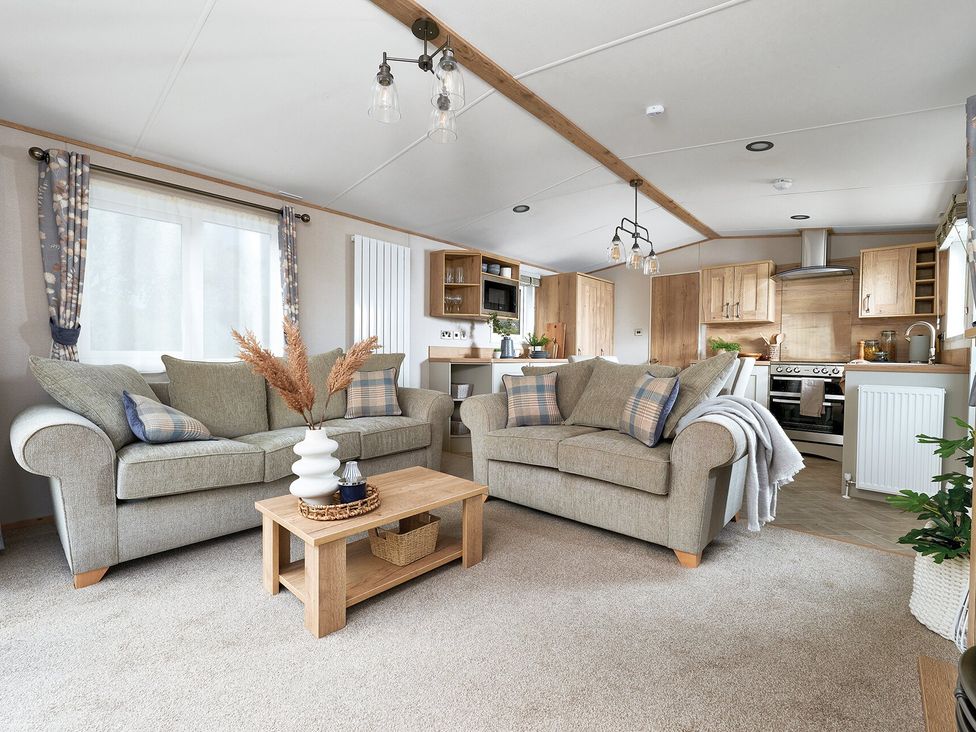 A living room with sofas and a coffee table at Juniper Waterside Spa Carlton Miniott near Thirsk