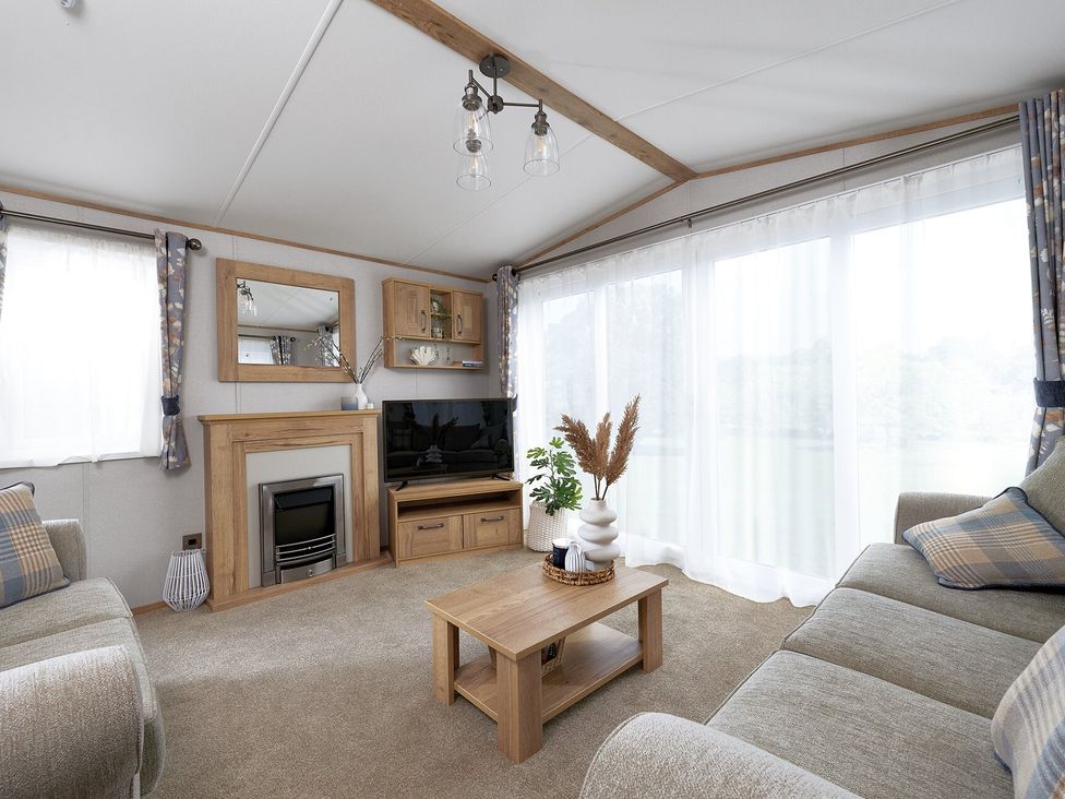A living room with a television and coffee table at Juniper Waterside Spa Carlton Miniott near Thirsk