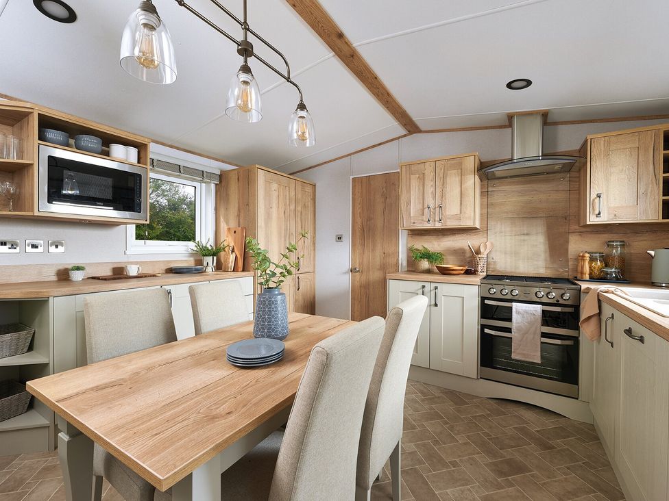 A kitchen with dining table and chairs at Juniper Waterside Spa Carlton Miniott near Thirsk
