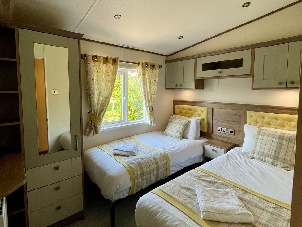 A bedroom with two beds and a window at Acacia Waterside Spa Carlton Miniott near Thirsk