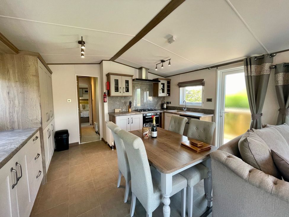 A kitchen with dining table and chairs at Acacia Waterside Spa Carlton Miniott near Thirsk