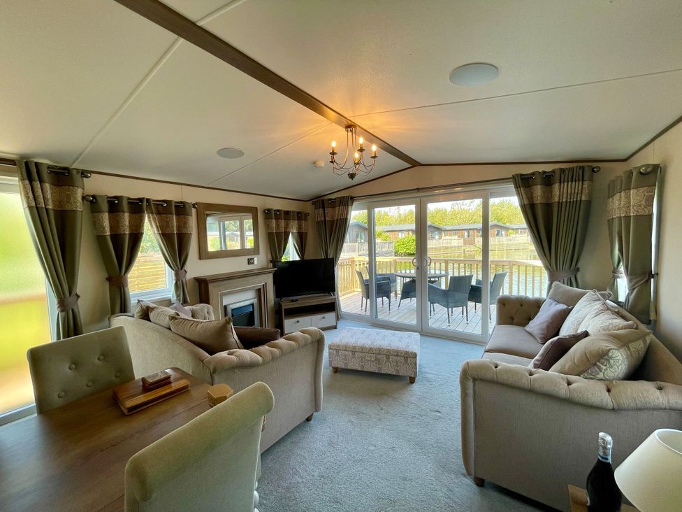 A living room with a sofa and television at Acacia Waterside Spa, Carlton Miniott near Thirsk