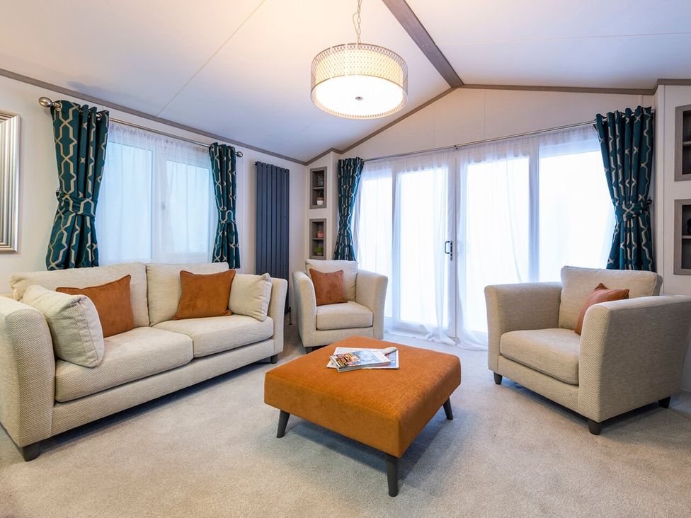 A living room with couches and a coffee table at Rowan Waterside Spa Carlton Miniott near Thirsk