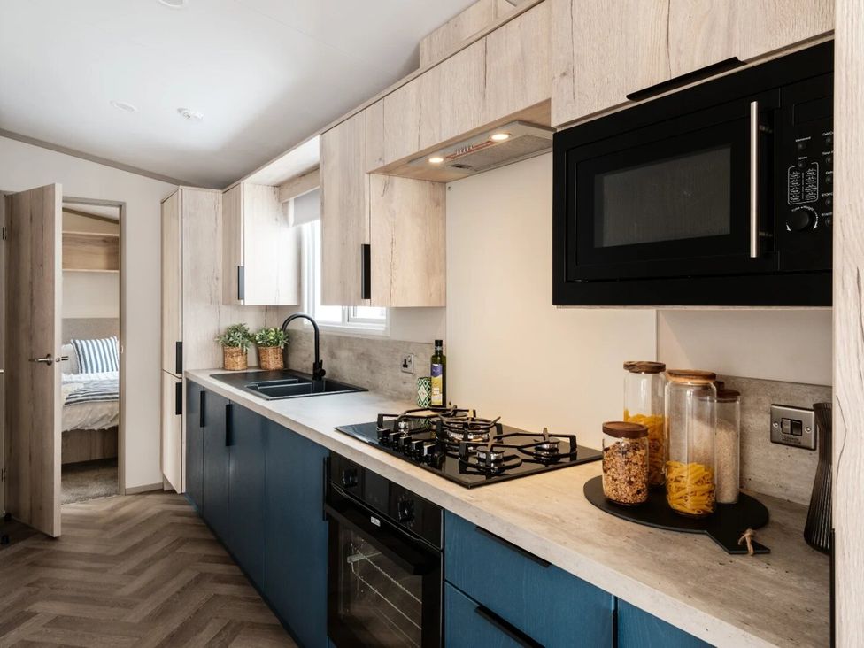 A kitchen with sink and stove at Rowan Waterside Spa Carlton Miniott near Thirsk