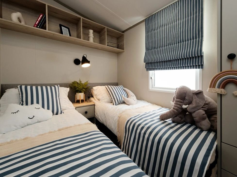 A bedroom with two beds and stuffed animals at Rowan Waterside Spa Carlton Miniott near Thirsk
