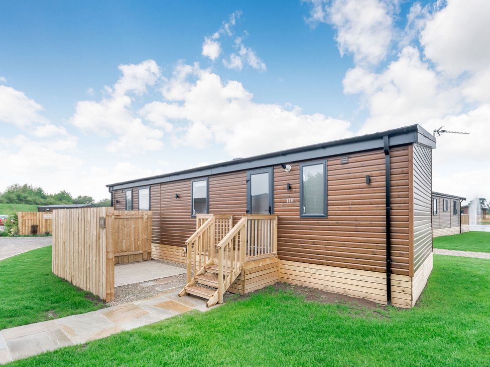A wooden lodge with stairs and a fence in Cedar Carlton Miniott near Thirsk
