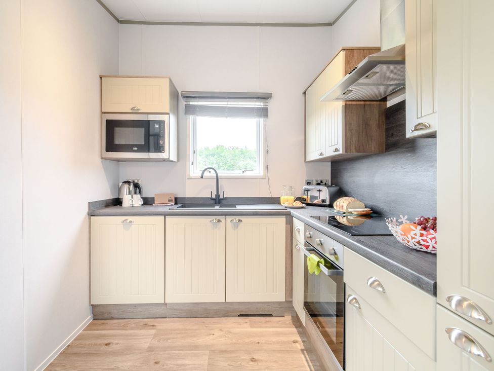 A kitchen with countertop appliances and cabinet storage at Cedar in Carlton Miniott near Thirsk