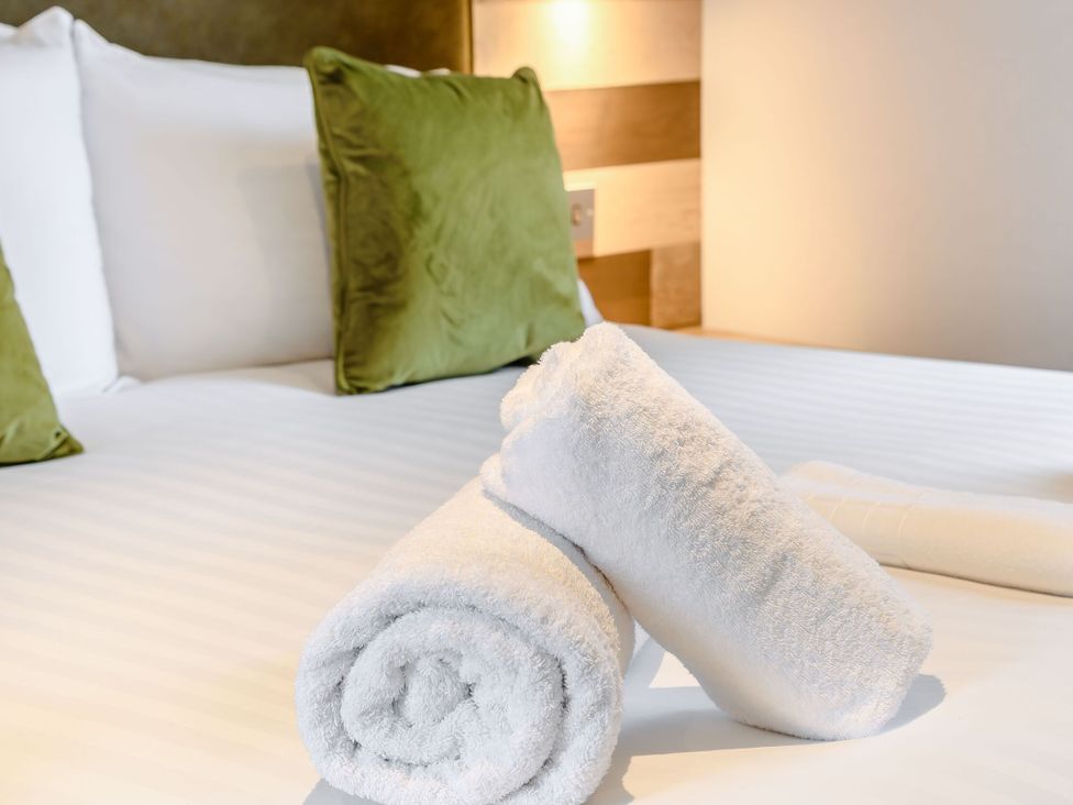 A bedroom with towels and pillows on the bed at Cedar in Carlton Miniott near Thirsk