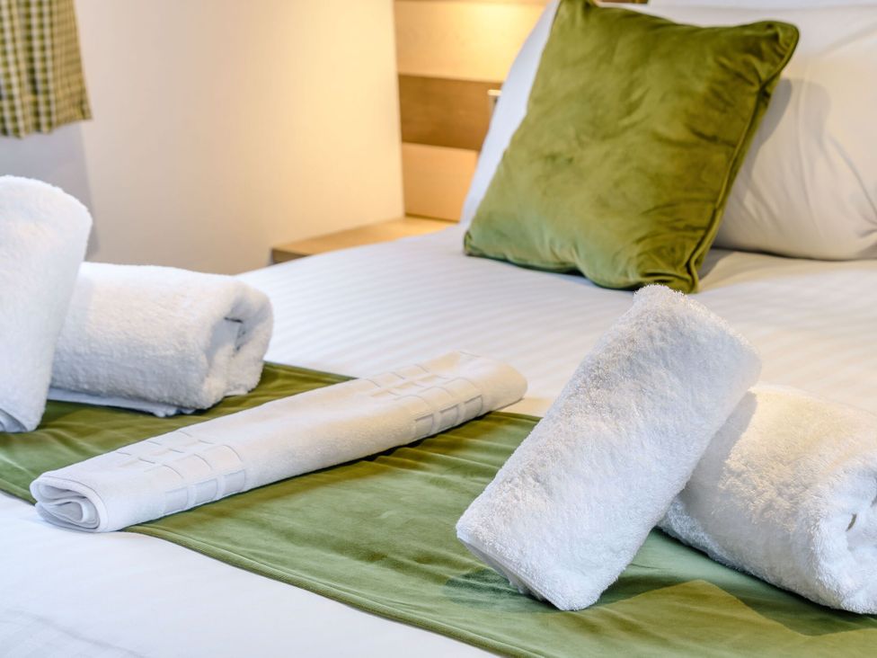 A bed with towels and a pillow at Cedar in Carlton Miniott near Thirsk