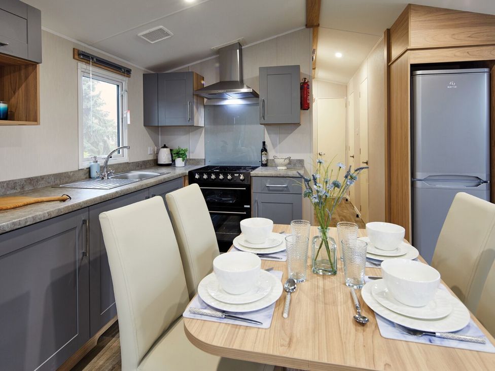 A kitchen with a dining table and chairs at Banyan Waterside Spa Carlton Miniott near Thirsk