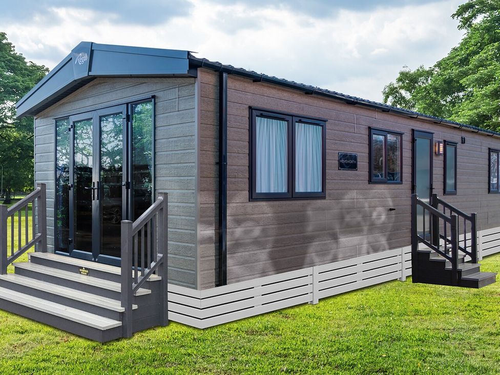A mobile home with steps and windows at Ellery Waterside Spa Carlton Miniott near Thirsk