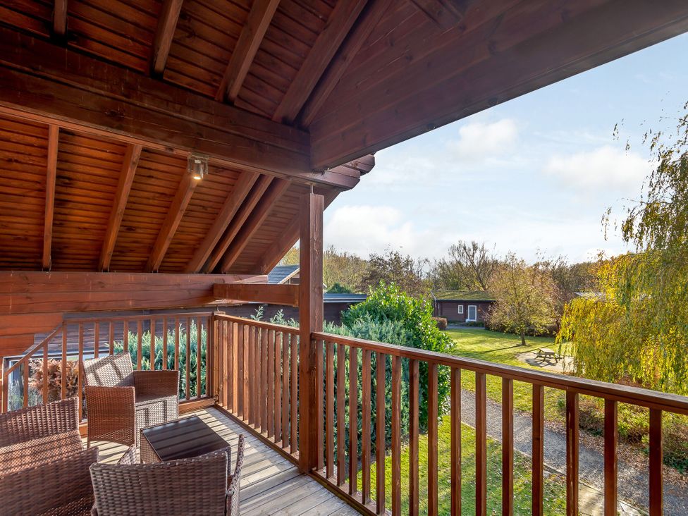 A balcony with seating overlooking garden at Birch Waterside Spa Carlton Miniott near Thirsk