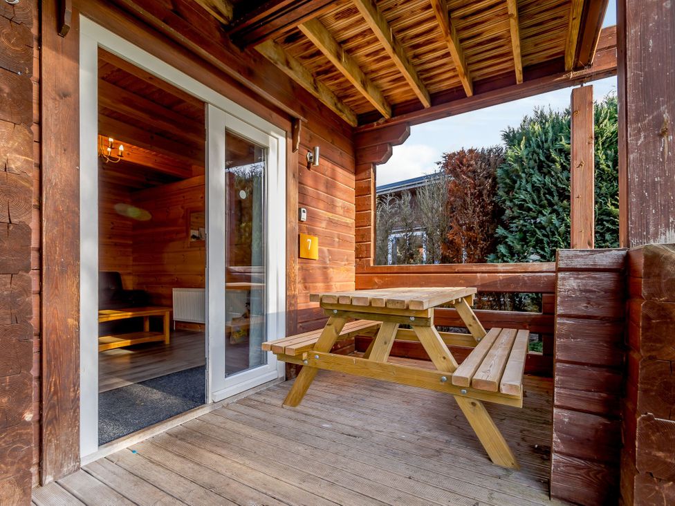 An outdoor area with a wooden table and chairs at Birch Waterside Spa Carlton Miniott near Thirsk
