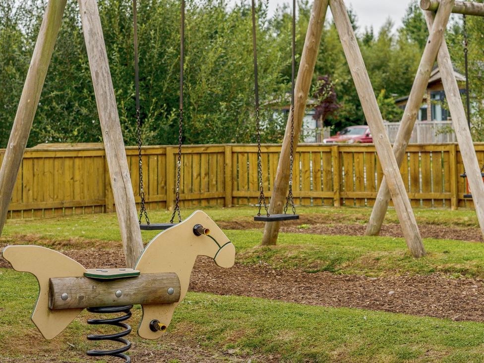 A playground with a spring horse and swings at Birch Waterside Spa Carlton Miniott near Thirsk