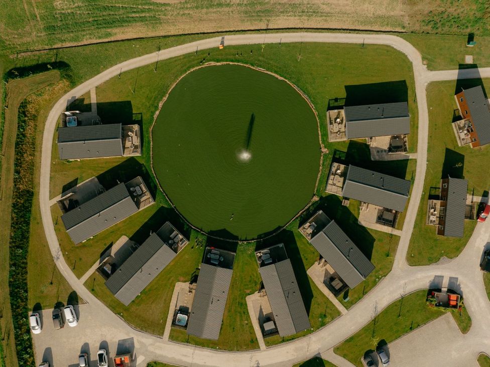 Aerial view of houses surrounding a pond at Birch Waterside Spa Carlton Miniott near Thirsk
